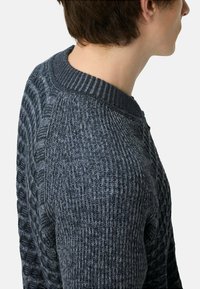 Sweter z dzianiny w ciemnoszarym kolorze z teksturowymi wzorami. Posiada prążkowany dekolt zaokrąglony i lekko dopasowany krój. Teksturowane rękawy dodają charakteru.