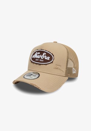 Beige adjustable baseball cap with a fabric front, mesh sides, and a brown embroidered logo. Distressed details near the brim.