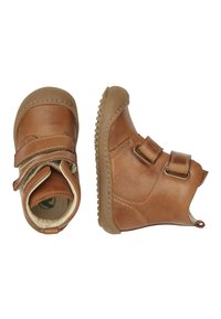 Botas de cuero marrón hasta el tobillo con dos correas ajustables, punta redonda y suela de goma texturizada. Interior forrado con material suave para mayor comodidad.