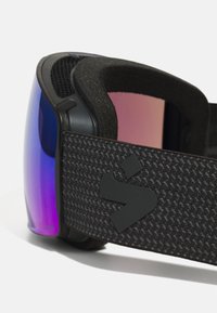 Skibril met een zwart textured band, paarse getinte lenzen en een glad zwart frame. Heeft een opvallend logo op de band.