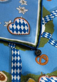 Zijden sjaal met een blauwe achtergrond, hartpatronen, bloemen, pretzels en een decoratief zwart etiket in bloemvorm.
