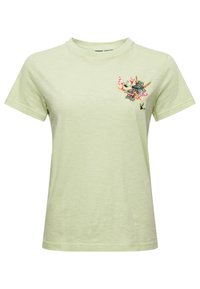 Camiseta de algodón verde claro con cuello redondo y mangas cortas. Presenta un bordado colorido de un dragón y acentos florales en el lado izquierdo del pecho.