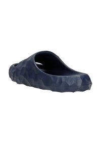 Navy blue clogs with a textured 3D hexagonal pattern, made from flexible material, featuring a wide opening and rounded shape.