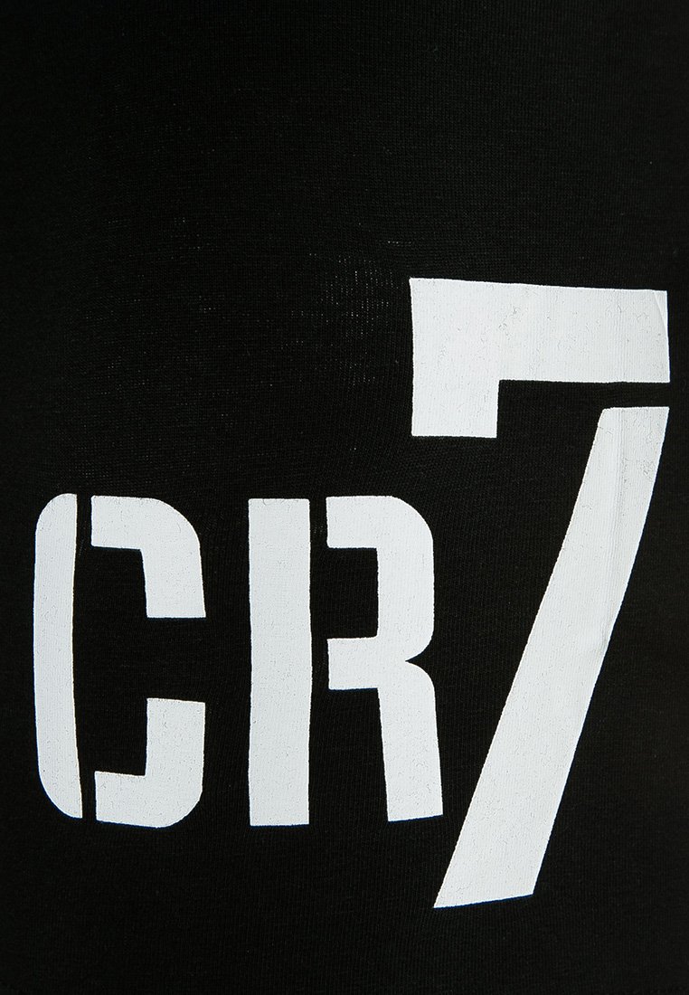 Tessuto nero opaco con il grande testo bianco stampato "CR7" in un carattere grassetto e a blocchi. Design sportivo distintivo.