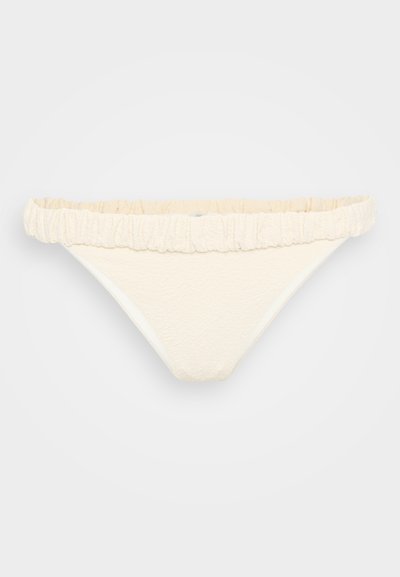Weißer Bikini-Unterteil mit strukturierter Oberfläche, featuring einem rüschigen Bund und klassischem Schnitt. Der Stoff wirkt weich und elastisch.