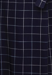 Marinfläkt med ett rutigt mönster i ljusblått och vitt. Texturen verkar jämn, med jämnt fördelade rutlinjer som skapar en strukturerad känsla.