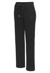 Schwarze Sweatpants aus weichem Stoff, mit einem Kordelzugbund, schmal zulaufenden Beinen und einem dezent auf dem Oberschenkel aufgedruckten Logo.
