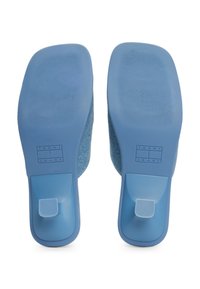 Baskets slip-on bleues avec une tige en tissu texturé, des semelles en caoutchouc et un détail de marque sur le talon. Finition lisse et forme arrondie.