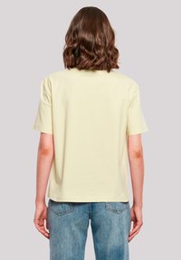 Short-sleeved, pastel yellow cotton t-shirt with a relaxed fit. Features a round neckline and smooth, soft texture. Back view only.