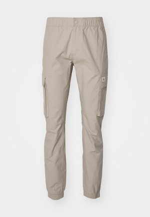 Pantaloni cargo beige realizzati in tessuto leggero, dotati di una cintura elastica, tasche laterali e polsini elastici alla caviglia.