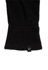 Černá fleecová rukavice s texturovaným povrchem, vhodným designem a šitým lemem. Obsahuje malou bílou nášivku s logem Nike na zápěstí.