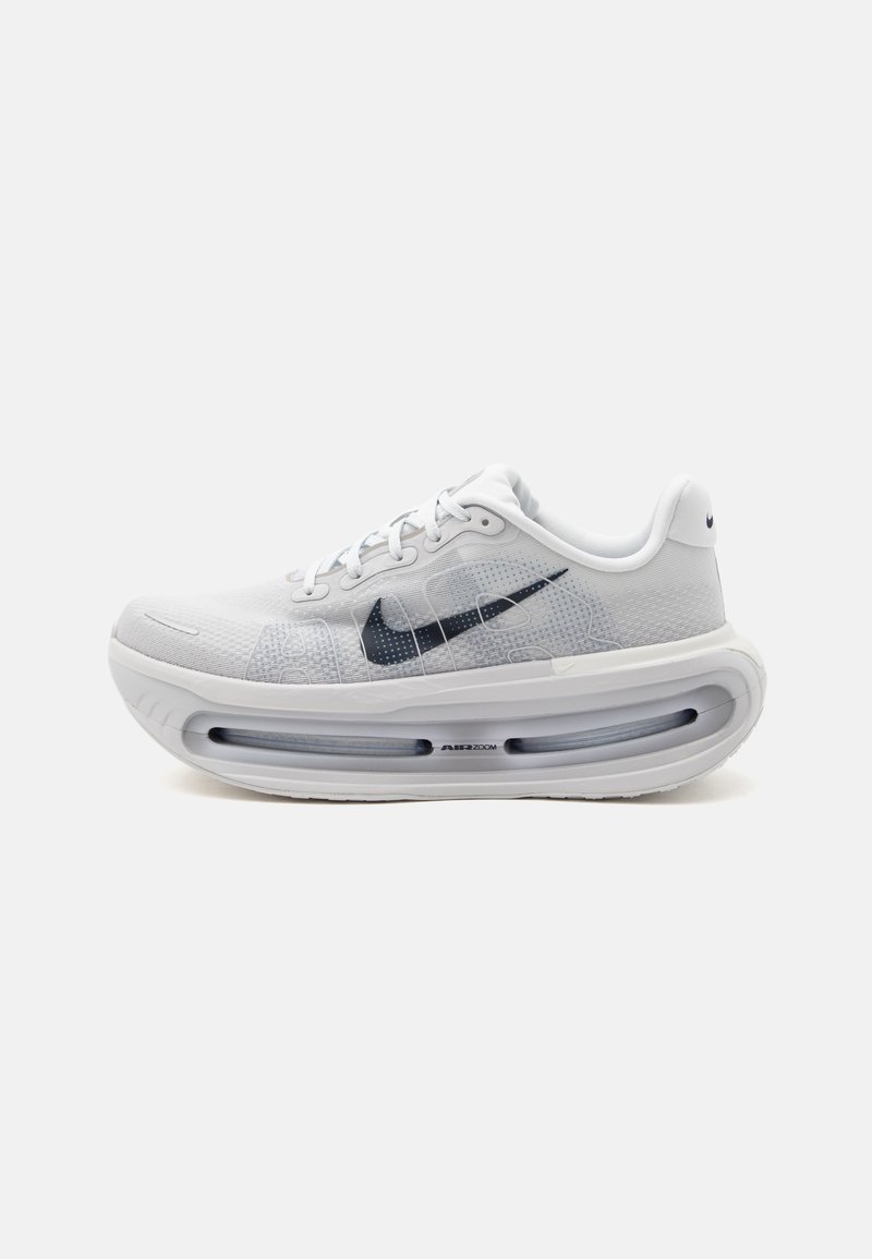 Λευκό παπούτσι Nike για τρέξιμο με μαύρο λογότυπο Swoosh, σχεδιασμό με κορδόνια και παχιά αεροπορική σόλα με την ένδειξη Air Zoom σε απλό φόντο.