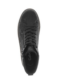 Zwarte leren sneaker met een gestructureerd oppervlak, ronde neus en frontsluiting. Voorzien van een zijrits en een bruine rubberen zool. Binnenin staat de merknaam.