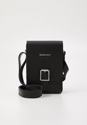 Schwarze Leder-Umhängetasche mit silberner Schnalle und verstellbarem Riemen, mit Dr. Martens-Logo auf der Vorderklappe.