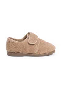 Zapatilla de casa texturizada en tono marrón, hecha de tela suave, con un cierre de tira ancha y una suela de goma baja y flexible para mayor comodidad y facilidad de uso.