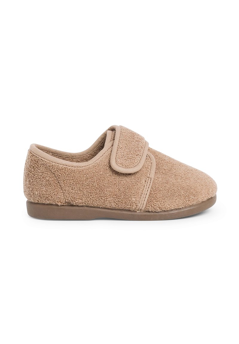 Zapatilla de casa texturizada en tono marrón, hecha de tela suave, con un cierre de tira ancha y una suela de goma baja y flexible para mayor comodidad y facilidad de uso.