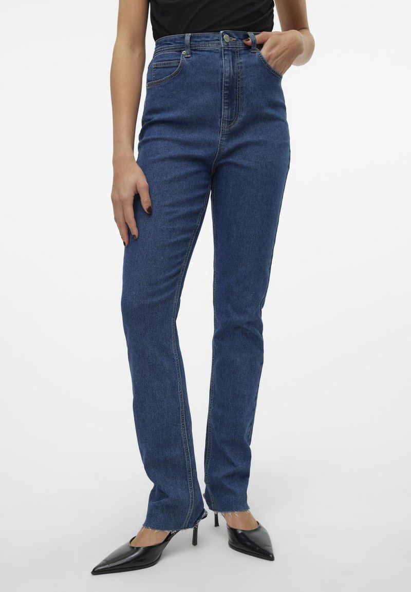 Modre jeans s visokim pasom iz denima, ravne nogavice z razfrkanim robom, kontrastni šivi, pet žepov in kovinski gumb za zapiranje.