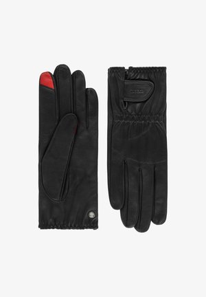 Schwarze Lederhandschuhe mit roten Akzenten am Daumen, elastisch am Handgelenk für einen angenehmen Sitz, mit einem markanten Logo-Patch im Handgelenkbereich.