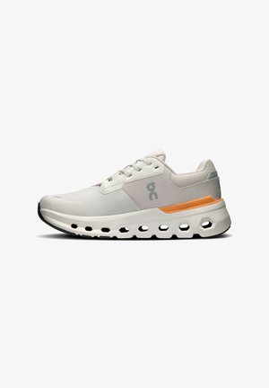 Heled hallikas spordijalats, millel on sile kangas pealis, oranž aktsent, peegelduv logo ja paks, pehmendusega talla osa, kus on kuusnurksete avade lõiked.