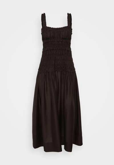 Robe noire sans manches avec corsage smocké et bretelles froncées ; présente une jupe fluide et ample avec une surface texturée et un léger éclat.