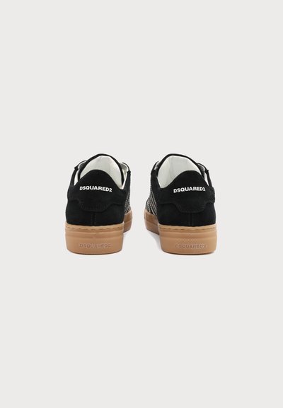 Ζευγάρι μαύρα χαμηλά sneakers με λαστιχένιες σόλες, με το λογότυπο "DSQUARED2" στην ταμπέλα της φτέρνας και στη σόλα, απεικονισμένα από πίσω σε απλό φόντο.