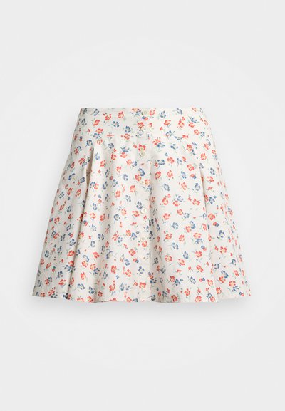 Gonna floreale in tessuto crema, con fiori rossi e blu. Forma ad A con pieghe in vita e chiusura frontale con bottoni.