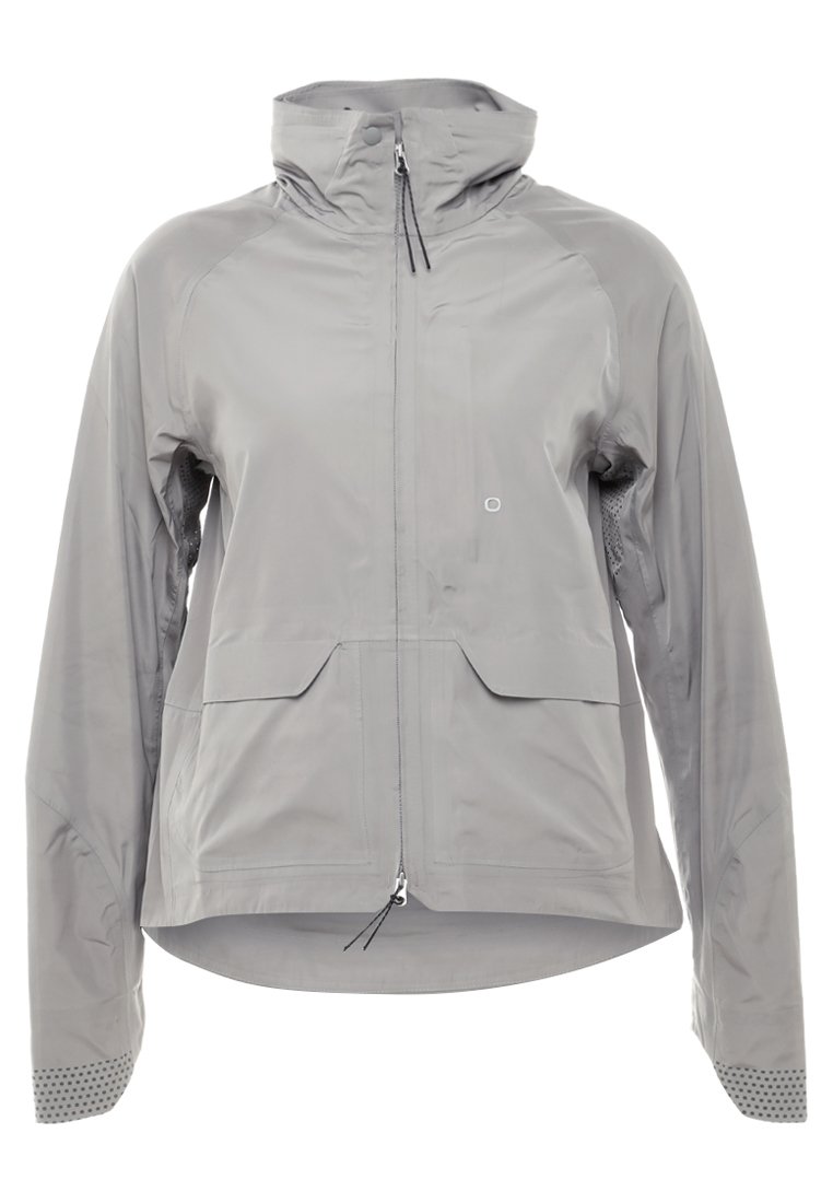 Hellgraue wasserdichte Jacke mit einem Frontreißverschluss, verstellbarem Kapuze und Netznähten. Sie verfügt über zwei Fronttaschen und strukturierte Bündchen.