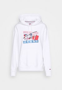 Biała bluza z kapturem z przednią kieszenią kangurką, z kolorowym nadrukiem w odcieniach różu, czerwieni i niebieskiego, na którym widnieje napis 'Tommy Jeans'.