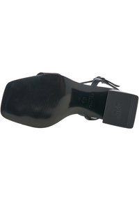 Sandal con tacco alto nero, suola texturizzata, tacco a blocco largo e cinturini sottili alla caviglia. Presenta un marchio in rilievo sul tacco. Taglia 37.