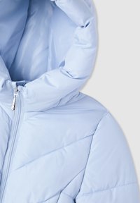 Giacca a vento blu chiaro con cappuccio, chiusura con zip e design a rombi trapuntato con texture liscia e lucida.