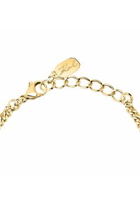 Bracelet en chaîne en métal doré avec maillons ovales, fermoir mousqueton et une plaque gravée "Karl". Texture lisse, finition polie.