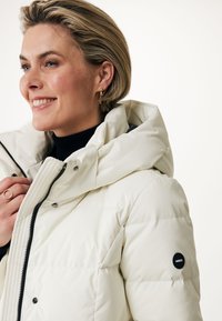 Giacca puffer bianca con cappuccio, dotata di zip nera e bottoni a pressione. Design trapuntato e testurizzato con una patch del logo sulla manica.