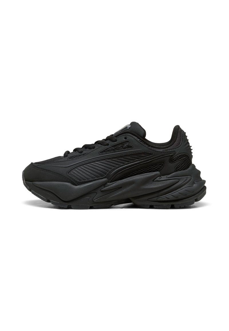 Sneaker sportivo nero con tomaia in materiale sintetico e strati di rete, suola spessa scolpita e chiusura con lacci, mostrato dal lato esterno su sfondo bianco.