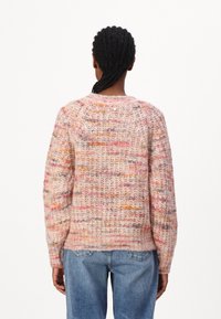 Sweter dziany w pastelowych odcieniach różu, pomarańczy i kremu. Teksturowana włóczka, luźny krój i opadające ramiona. Szczegóły ściagacza u dołu.