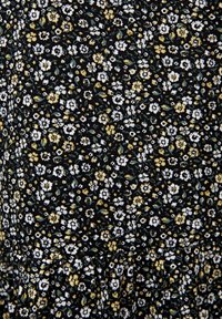 Tissu noir avec un petit motif floral en blanc, jaune et vert. Le design comprend des fleurs délicates et des feuilles avec une surface texturée.