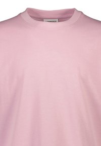 Ljusrosa bomullströja med rund halsringning och korta ärmar, med en mjuk textur och en enkel design. Inga mönster eller detaljer.