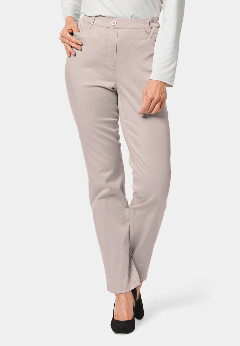 Pantalons beige clair à coupe slim, dotés de poches avant, d'une fermeture à bouton et d'une texture de tissu lisse et extensible.