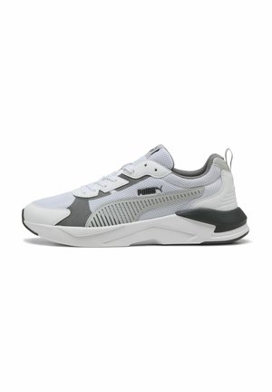 Chaussure de sport Puma blanche et grise avec tige en mesh, fermeture à lacets et semelle rembourrée, présentée de profil sur fond blanc.