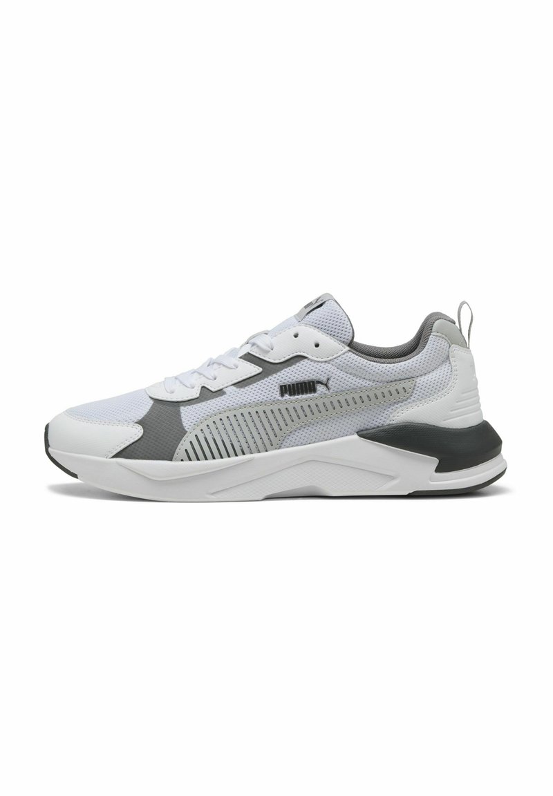 Chaussure de sport Puma blanche et grise avec tige en mesh, fermeture à lacets et semelle rembourrée, présentée de profil sur fond blanc.