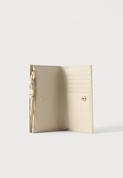 Cartera de cuero crema abierta que muestra seis ranuras para tarjetas, un bolsillo con botón a presión y un compartimento con cremallera con herrajes en tono dorado.