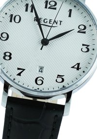 Cadran de montre blanc avec des chiffres et des aiguilles noirs affichant 1:55:06, fenêtre de date à 6 heures, boîtier en argent et bracelet en cuir noir.