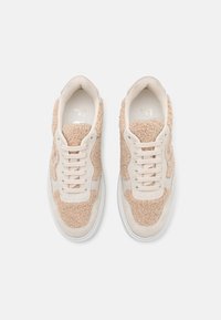Šněrovací tenisky v krémové a béžové barevné kombinaci. Mají texturovaný, huňatý svršek a hladké akcenty. Gumová podrážka pro lepší trakci.
