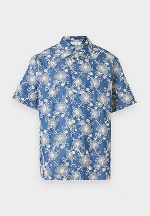 Modra srajca s kratkimi rokavi na gumbke z belo cvetlično čipkasto vzorcem in ostrim ovratnikom na enobarvnem ozadju.