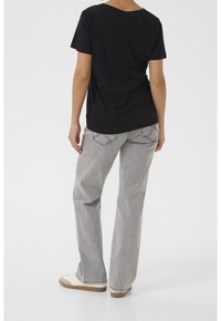 Svart bomullströja med kortärmar och en enkel design, kombinerad med ljusgrå denimjeans med söms detaljer och bakfickor.