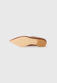 Bruine leren puntneus flat shoe met een gladde textuur. Beschikt over een beige rubberen zool en een gouden accent rits aan de zijkant.
