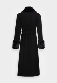 Manteau noir long avec un col et des poignets en fausse fourrure. Design ceinturé, silhouette droite et texture lisse tout au long.