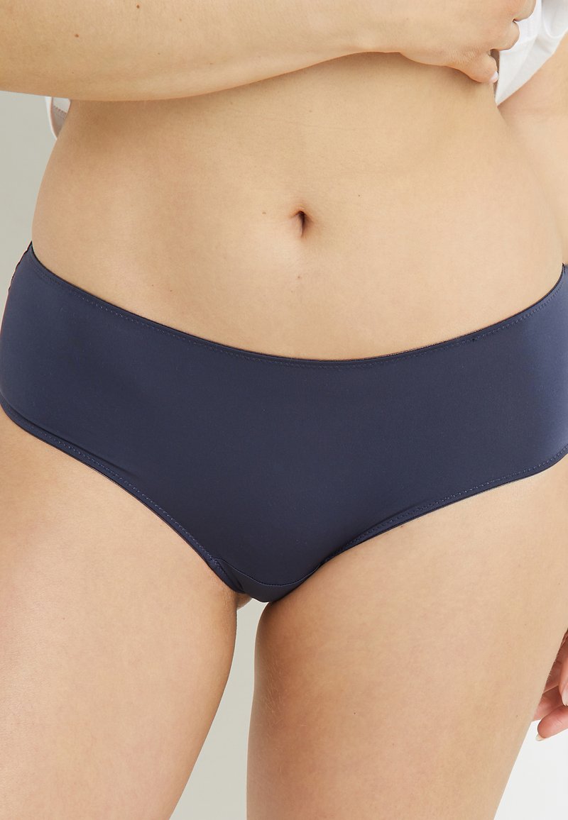 Culotte de bikini bleu marine fabriquée en tissu lisse et extensible, avec un design taille mi-haute et des coutures plates pour un confort optimal.