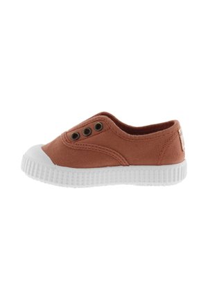 Zapatilla de lona color óxido sin cordones con puntera de goma blanca y suela blanca texturizada. Presenta tres ojales a los lados.
