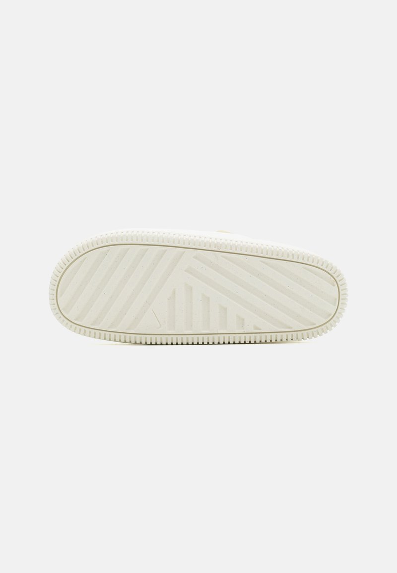 Suela de zapatilla blanca con relieves texturizados y un diseño minimalista. Presenta un logotipo elevado y un patrón de rayas horizontales para mayor tracción.