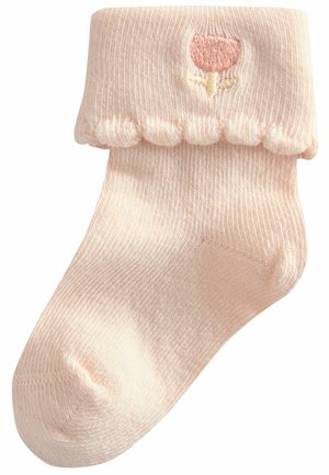 Rosa gerippte Socke mit gewelltem oberen Rand, ausgestattet mit einem kleinen gestickten Blumenmotiv. Weicher Stoff, knöchellange Ausführung.